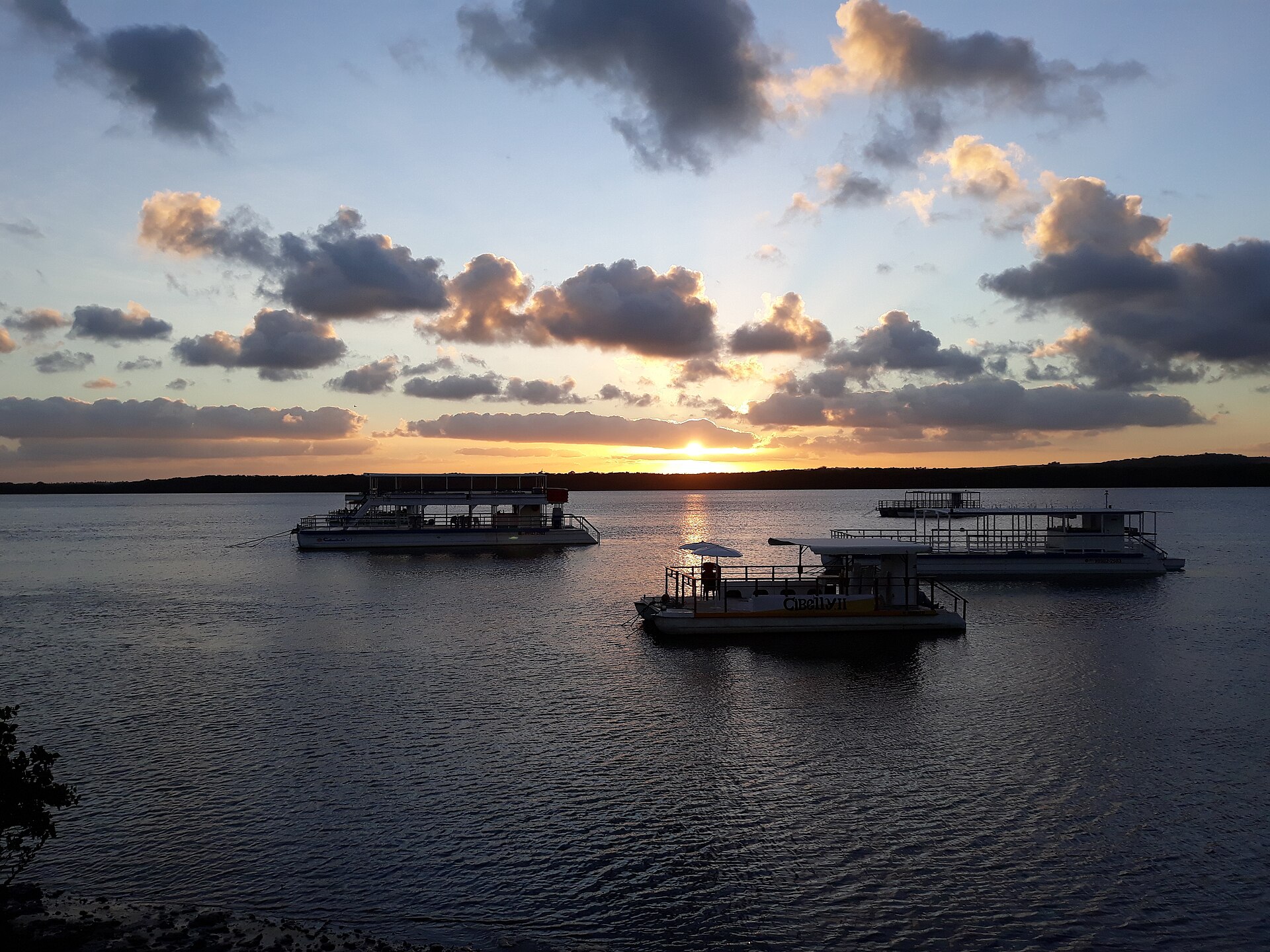 Pôr do sol na praia fluvial do Jacaré, em Cabedelo, com barcos no Rio Paraíba